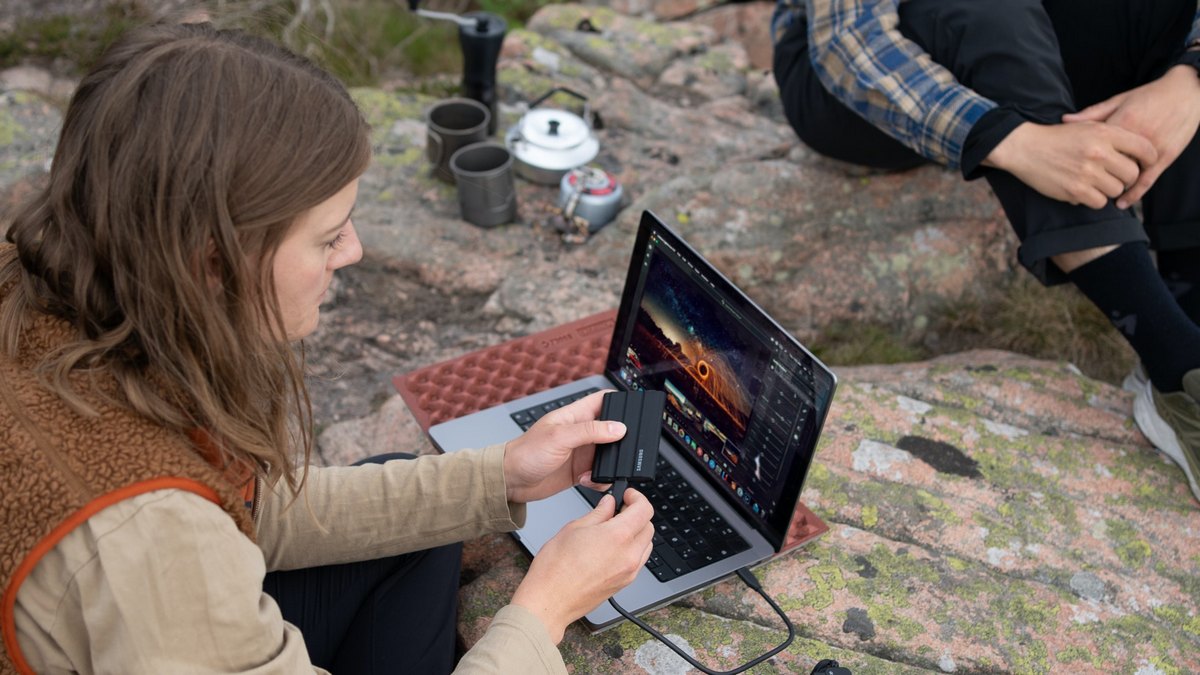 Wyprawa w góry. Turystyka ładująca telefon za pomocą laptopa